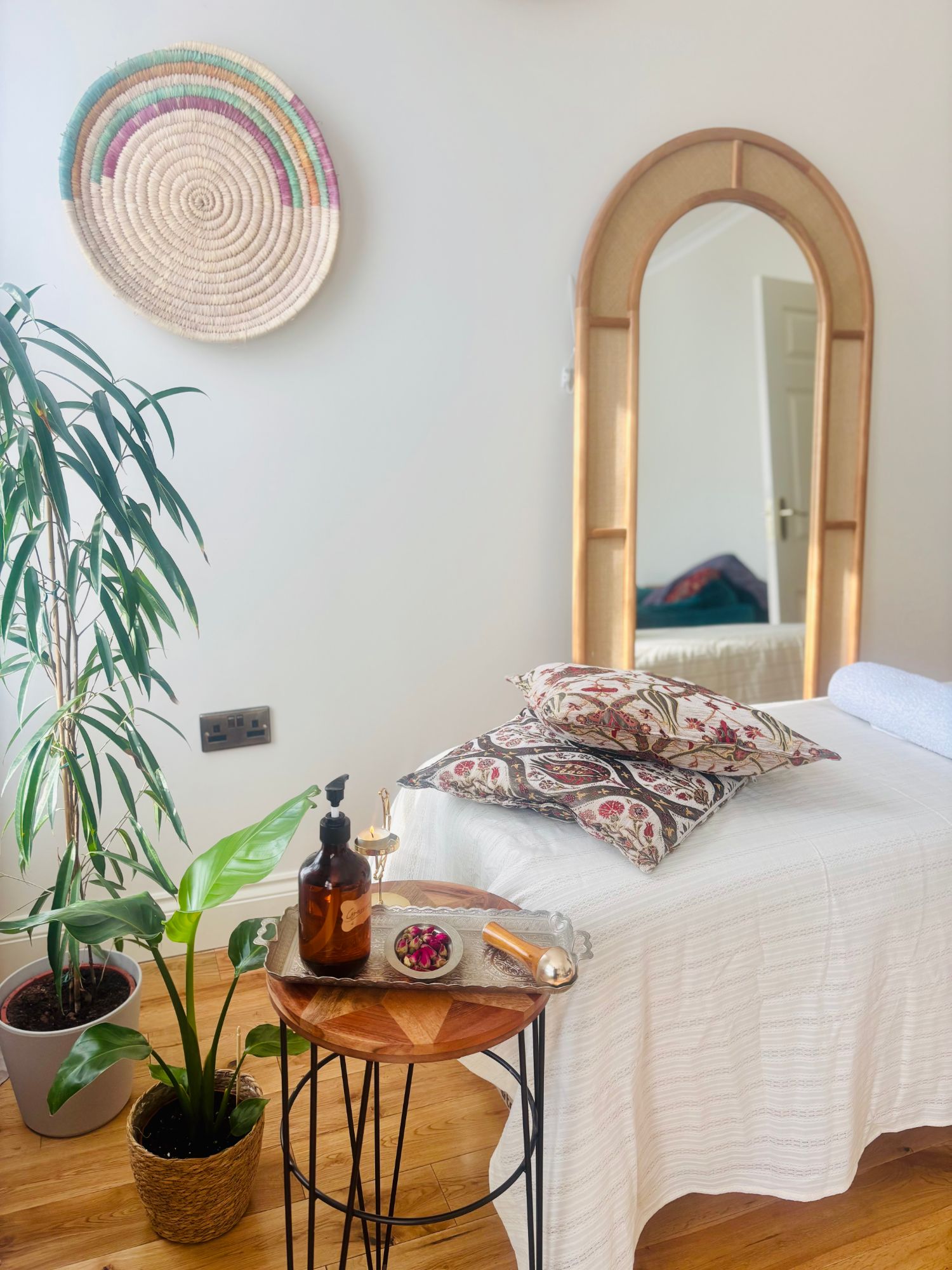 Treatment table with rose buds and oil in a calm, plant-filled room
